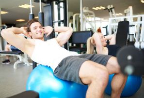 a guy doing sit ups on the exercise ball